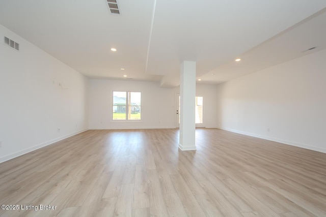 empty room with visible vents, light wood-style flooring, baseboards, and recessed lighting