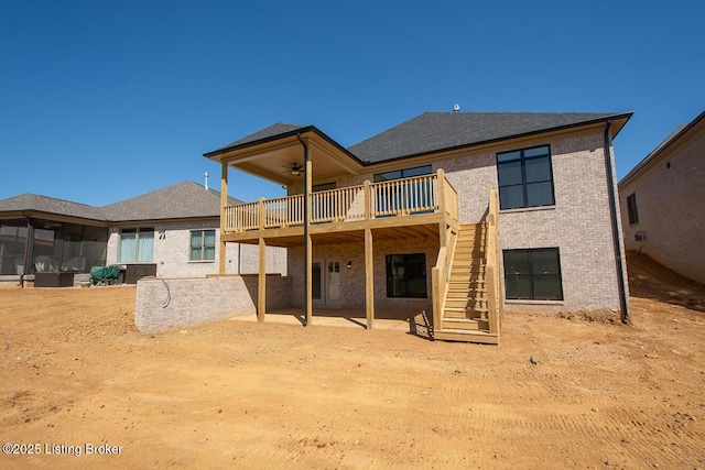 rear view of house featuring a patio, a ceiling fan, a wooden deck, brick siding, and stairs