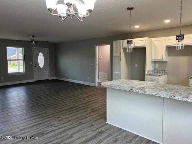 5415 Mount Holyoke Dr, Louisville, KY 40216 - kitchen with white cabinets, dark wood finished floors, a chandelier, light stone countertops, and baseboards