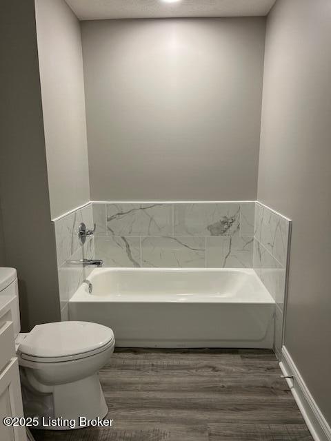 5415 Mount Holyoke Dr, Louisville, KY 40216 - bathroom with toilet, a bath, and wood finished floors