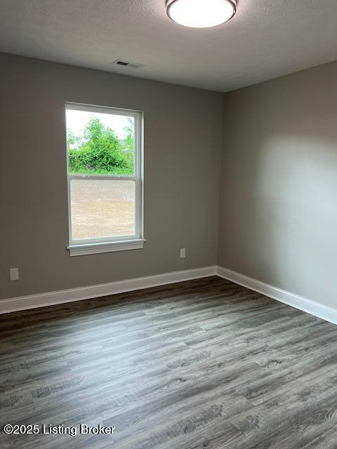5415 Mount Holyoke Dr, Louisville, KY 40216 - empty room featuring dark wood-style floors, baseboards, and a textured ceiling