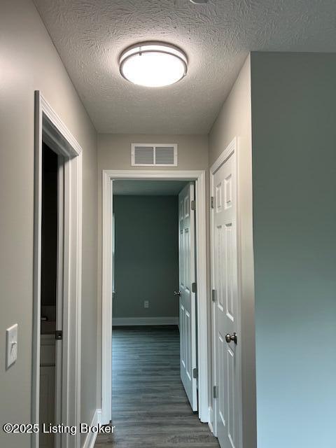 5415 Mount Holyoke Dr, Louisville, KY 40216 - hallway with dark wood-style floors, a textured ceiling, and baseboards