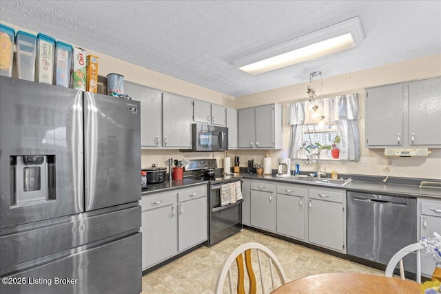 1312 Cedar Springs Pkwy, La Grange, KY 40031 - kitchen featuring a sink, stainless steel appliances, gray cabinets, a textured ceiling, and dark countertops