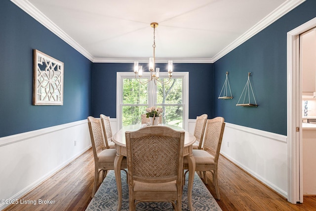 dining area with a chandelier, wood finished floors, crown molding, and baseboards
