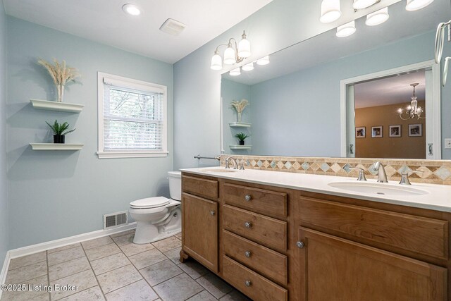 full bath with toilet, a chandelier, double vanity, baseboards, and tile patterned flooring