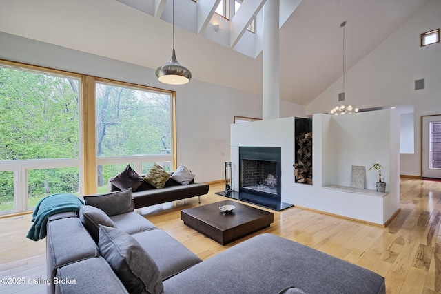 1301 S Buckeye Ln, Goshen, KY 40026 - living area with high vaulted ceiling, hardwood / wood-style flooring, a fireplace with raised hearth, and a chandelier