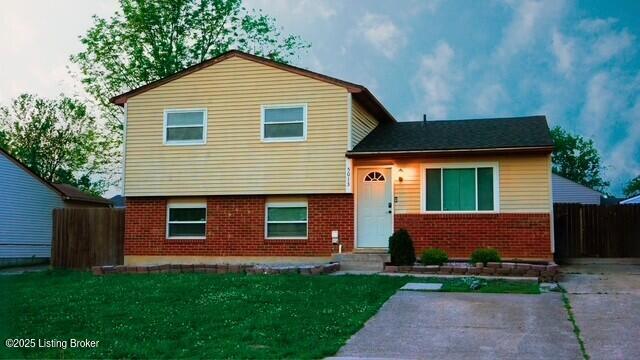 5013 Tolkien Ct, Louisville, KY 40229 - split level home featuring a front lawn, brick siding, and fence