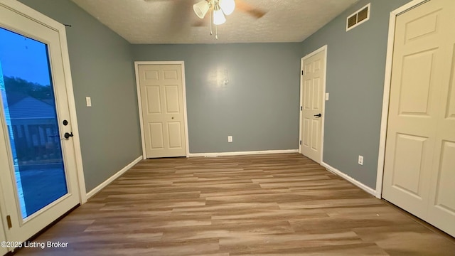 5013 Tolkien Ct, Louisville, KY 40229 - interior space featuring a textured ceiling, visible vents, wood finished floors, and baseboards
