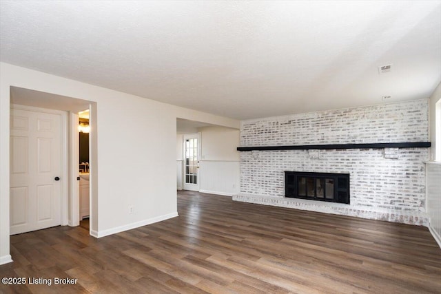 4804 Mike Ct, Louisville, KY 40291 - unfurnished living room featuring wood finished floors, a textured ceiling, visible vents, baseboards, and a large fireplace