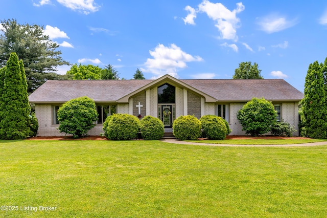 view of front of home with brick siding, a front lawn, and roof with shingles