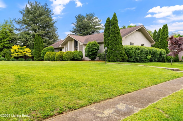view of front facade with brick siding and a front lawn