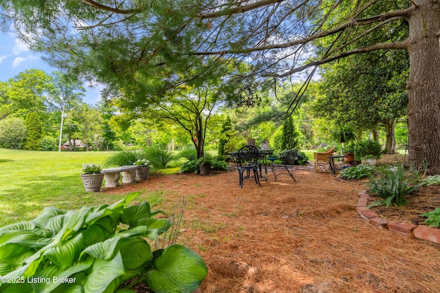 view of green lawn with view of scattered trees
