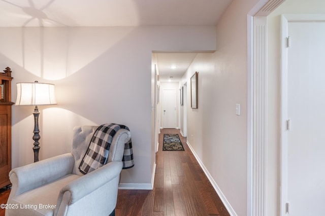 hall featuring dark wood-style flooring and baseboards