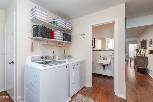 clothes washing area featuring washing machine and clothes dryer and dark wood finished floors