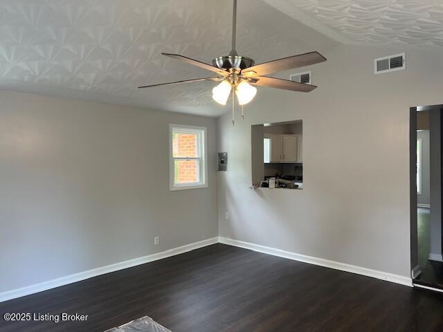 6100 Deady Dr, Louisville, KY 40258 - unfurnished room with dark wood-style flooring, a ceiling fan, vaulted ceiling, and baseboards