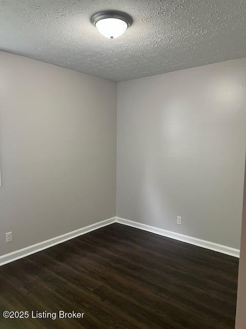 6100 Deady Dr, Louisville, KY 40258 - empty room with dark wood-style floors, a textured ceiling, and baseboards