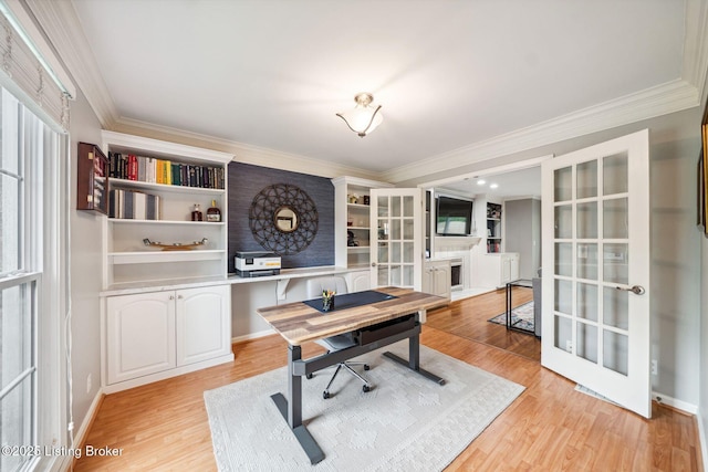 home office with french doors, ornamental molding, light wood-type flooring, a fireplace, and baseboards