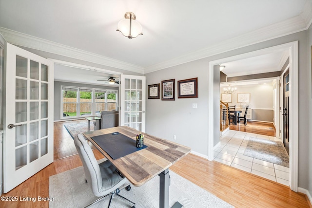 dining space featuring a chandelier, french doors, light wood-type flooring, and crown molding