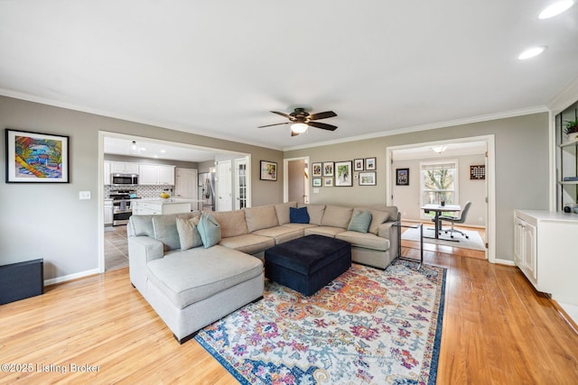 living room with light wood-style flooring, a ceiling fan, ornamental molding, baseboards, and recessed lighting