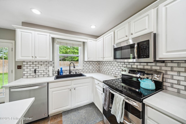 kitchen featuring stainless steel appliances, a sink, plenty of natural light, decorative backsplash, and recessed lighting