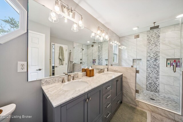 full bathroom featuring a stall shower and double vanity
