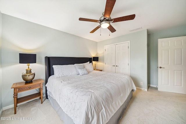 bedroom with light carpet, a closet, baseboards, and ceiling fan