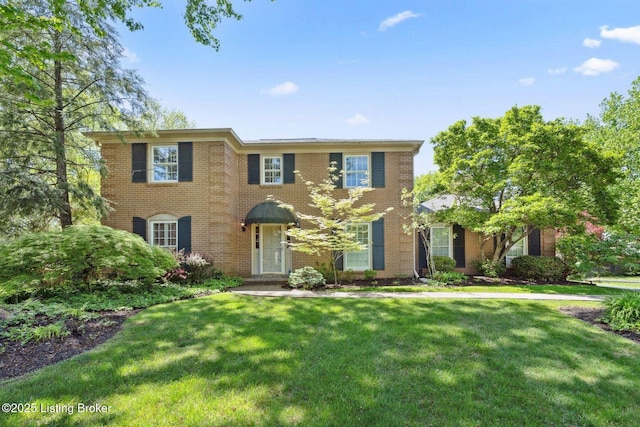 view of front of property featuring a front lawn and brick siding