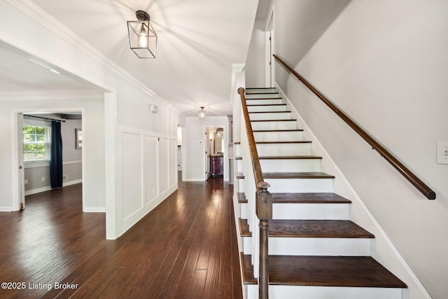 stairs with hardwood / wood-style flooring and ornamental molding