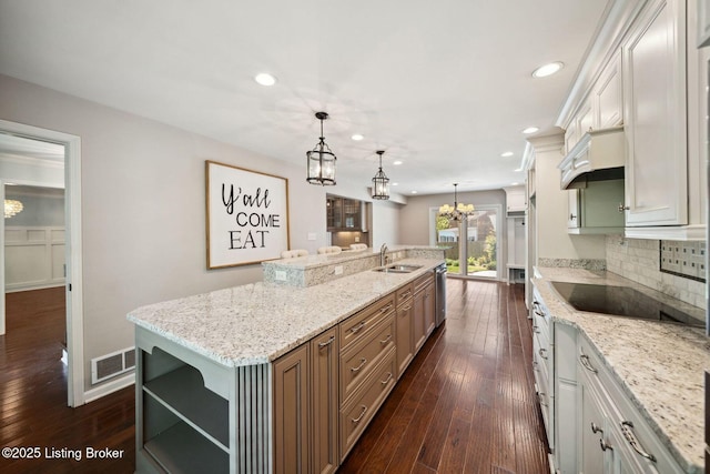 kitchen featuring open shelves, a sink, a chandelier, a spacious island, and stainless steel dishwasher