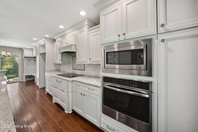 kitchen featuring stainless steel appliances, backsplash, recessed lighting, light stone countertops, and white cabinetry