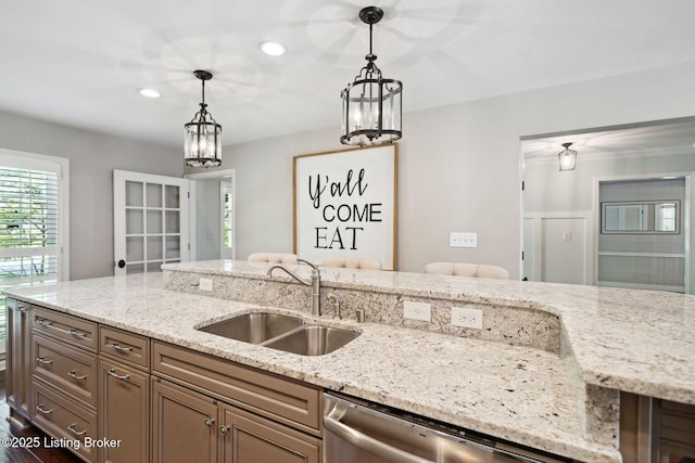kitchen with a sink, dishwasher, hanging light fixtures, light stone counters, and recessed lighting