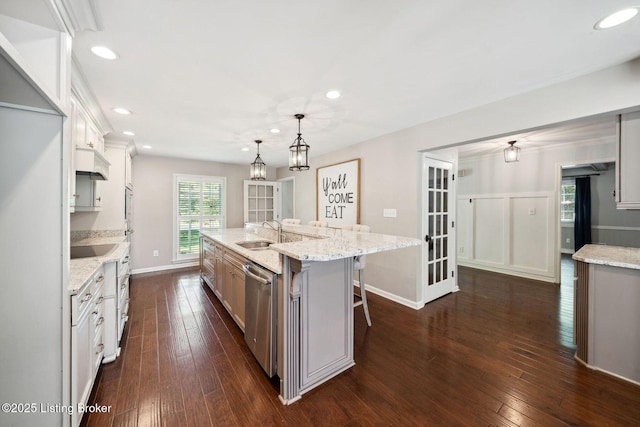 kitchen with paneled built in fridge, stainless steel dishwasher, a sink, dark wood finished floors, and recessed lighting