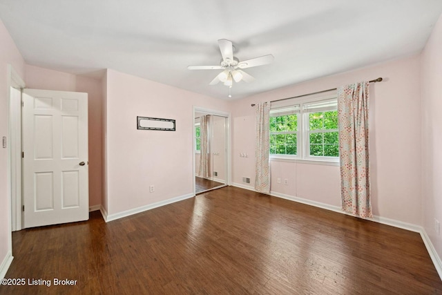 unfurnished bedroom featuring wood finished floors, baseboards, and ceiling fan