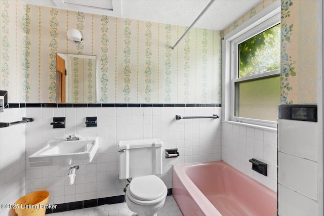 8004 Sherry Lynn Ct, Louisville, KY 40228 - full bathroom featuring a tub to relax in, tile walls, toilet, a sink, and a wainscoted wall