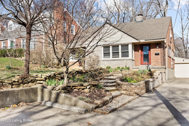 17 Denham Rd, Louisville, KY 40205 - view of front facade featuring brick siding, a chimney, a garage, a shingled roof, and concrete driveway