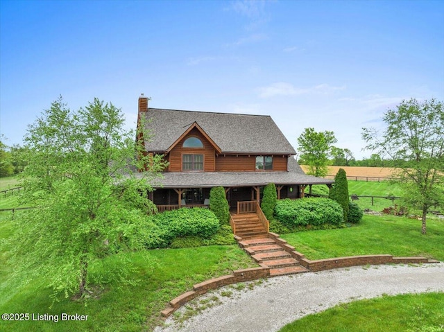 log cabin featuring covered porch, a chimney, a shingled roof, and driveway