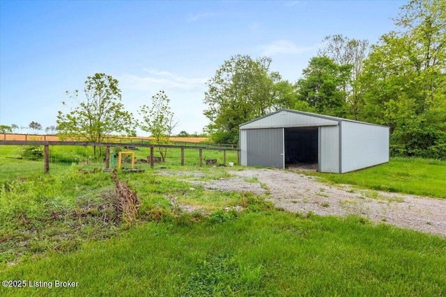 view of pole building with fence and a view of rural / pastoral area