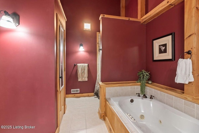 full bathroom with tile patterned floors, a tub with jets, and baseboards