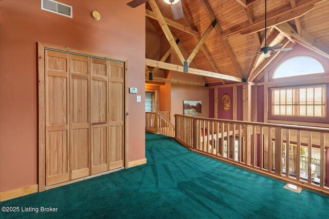 hall with wooden ceiling, beam ceiling, carpet floors, and high vaulted ceiling