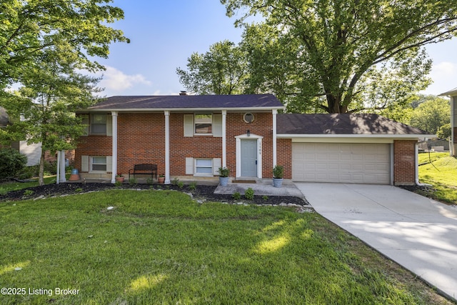 raised ranch with a garage, driveway, a front yard, and brick siding