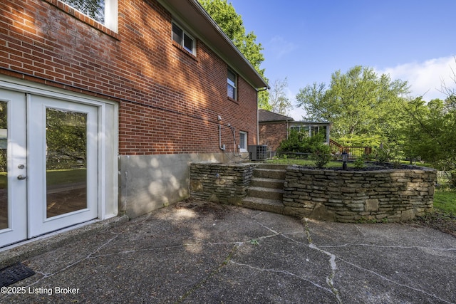 view of home's exterior featuring brick siding, a patio, and central AC unit