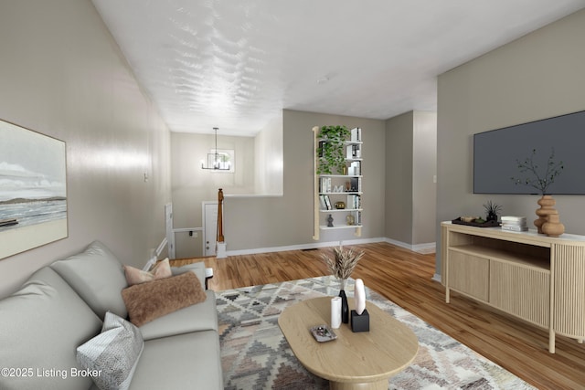 living area featuring wood finished floors, baseboards, and a chandelier