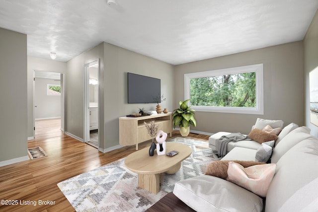 living room featuring baseboards and light wood-style floors