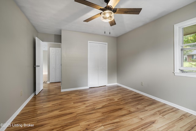unfurnished bedroom with light wood finished floors, baseboards, a closet, and ceiling fan