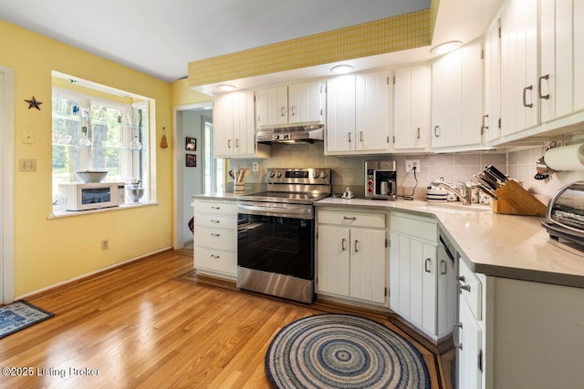 12715 Westport Rd, Louisville, KY 40245 - kitchen featuring stainless steel electric range, a sink, under cabinet range hood, light wood finished floors, and tasteful backsplash