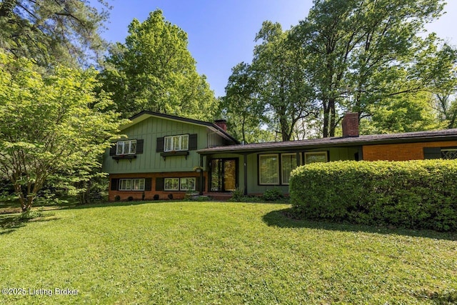 12715 Westport Rd, Louisville, KY 40245 - view of front of property with a chimney, a front lawn, board and batten siding, and brick siding