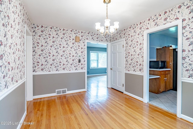 4305 Darbrook Rd, Louisville, KY 40207 - unfurnished room featuring wallpapered walls, light wood-style floors, and a chandelier