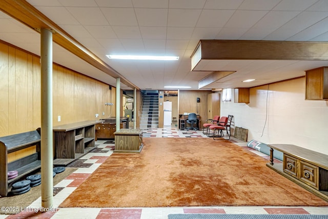4305 Darbrook Rd, Louisville, KY 40207 - finished basement featuring freestanding refrigerator, wood walls, tile patterned floors, and stairs
