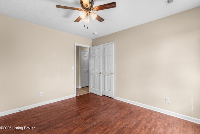 unfurnished bedroom with wood finished floors, baseboards, ceiling fan, and a textured ceiling