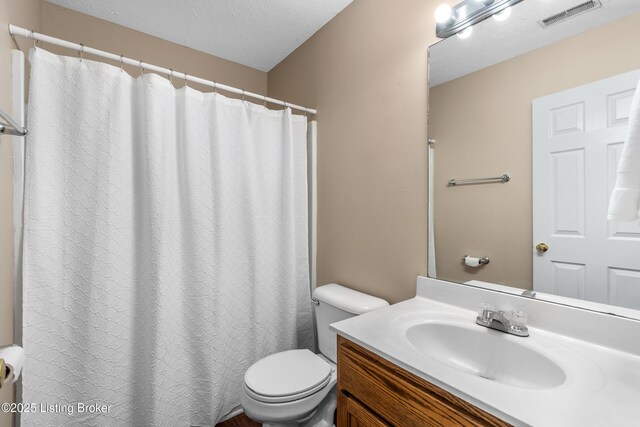 full bath with toilet, vanity, a textured ceiling, and a shower with curtain